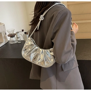 Detail of silver metallic ruched shoulder bag with knotted strap design for women