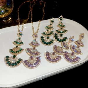 Close-up of fan-shaped pendant necklaces and tassel earrings with sparkling rhinestones