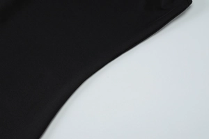 Detail showing high-quality black knit fabric texture and premium stitching on the dress