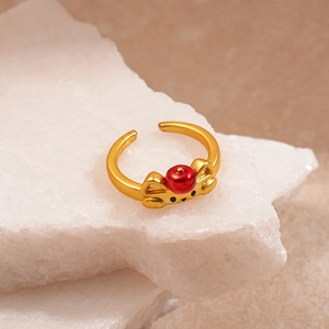 Detail of a vintage golden cat ring with a red bead on stacked white stones