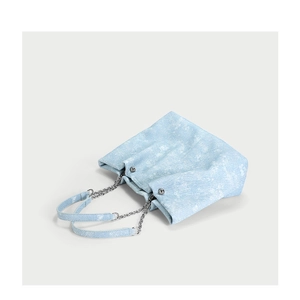 Ink blue denim tote bag with chain straps and white patterns on a white background