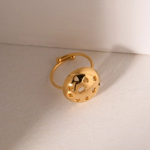 Golden heart cutout ring with adjustable open band on warm textured background
