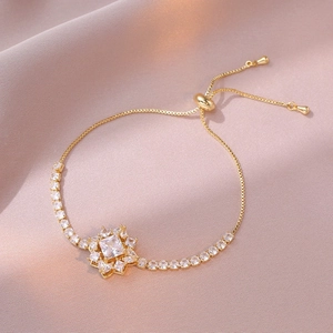 Detail of adjustable gold box chain bracelet featuring a square zircon center and slider clasp