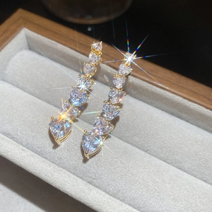 Close-up of 18K gold plated heart earrings with zircon stones in a velvet jewelry box