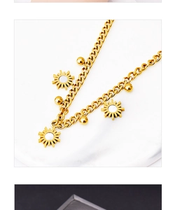 Detailed macro view of golden sun flower charms with white shell center and beads on chain