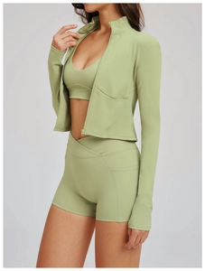 Dettaglio completo yoga elasticizzato con pantaloncini a vita incrociata e giacca verde