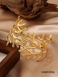 Gros plan détaillé du bracelet branche plaqué or 18k pesant 28,6g sur fond de soie douce
