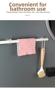 Self-adhesive white curtain rod holder with hooks holding pink towel and cleaning brush