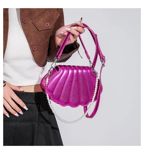 Details der magentafarbenen Muschel-Umhängetasche mit Perlenkette und Metallic-Finish