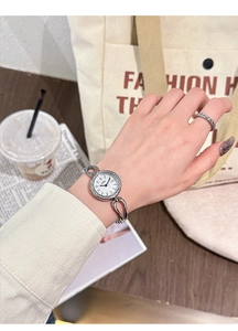Detail shot of a women's quartz watch with sparkling rhinestone bezel and silver metal strap