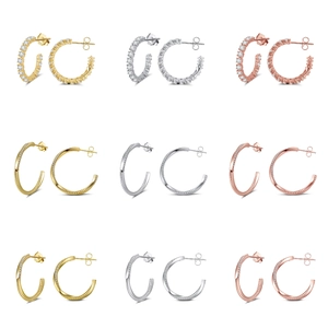 Macro detail of nine S925 sterling silver hoop earrings in gold, silver, and rose gold
