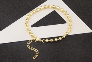 Detail of 18k gold plated bead bracelet showing lobster clasp and extension chain