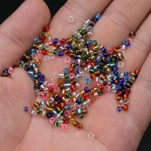 Colorful 2mm glass seed beads in hand for DIY jewelry making like necklaces and bracelets