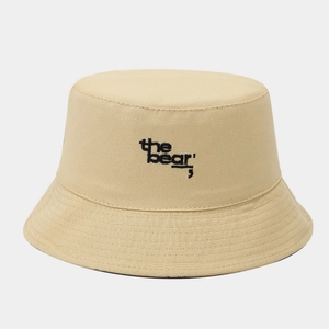 Close-up of the bear embroidery on a light khaki canvas sun hat with clean stitching