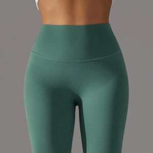 Close-up of wide waistband on high-waisted dark green yoga pants with seamless stitching