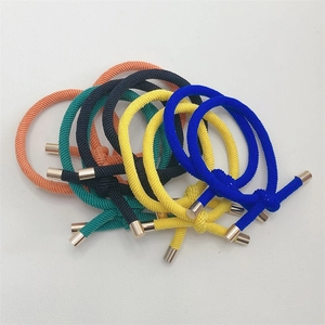 Close-up of colorful braided elastic hair ties with cylindrical metal buckles on a white background