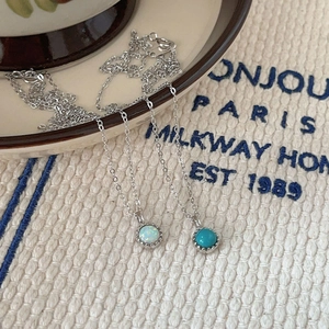 Minimalist s925 silver necklace featuring elegant opal and turquoise pendant on white fabric