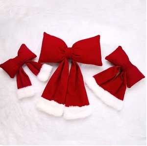 Three-piece red velvet Christmas bows with white faux fur edges on a soft plush background