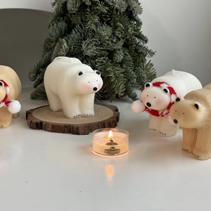 Detail shot of white polar bear candles with red scarves for Christmas holiday decor