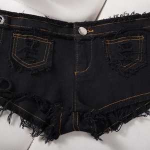 Dettaglio degli shorts in denim nero con cuciture a contrasto arancioni e orlo a frange
