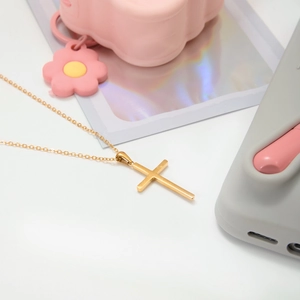 Detailed view of the 18K gold plated stainless steel cross pendant on a fine link chain