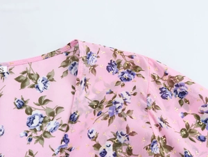 Dettaglio dello scollo in chiffon floreale con accenti dorati e etichetta taglia S