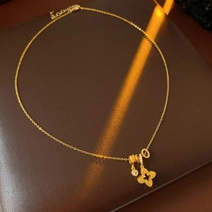 Macro view of 18k gold plated clover pendant with zircon detail on leather background
