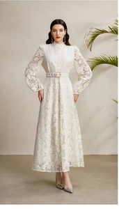 Detailed view of intricate lace texture and pearl button accents on a white midi dress