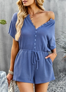 Close-up of blue waffle knit romper featuring V-neck buttons and waist drawstring