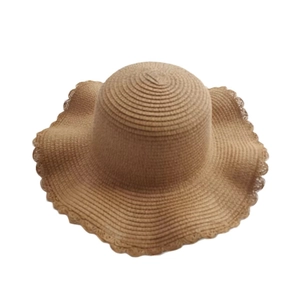 Detailed close-up of brown woven straw sun hat showing wave brim and texture