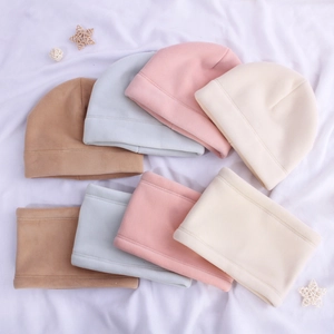 Detailstruktur von weichem Fleece-Wintermützen- und Schal-Set in verschiedenen Pastellfarben