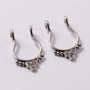 Detailed view of silver stainless steel septum rings with beads and clear gemstones