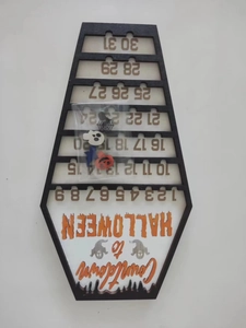 Wooden coffin-shaped Halloween countdown calendar with spider and bat accessories