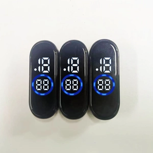 Three oval LED modules for smart bracelets showing blue digital time on a white surface