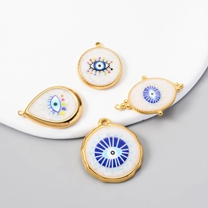 White enamel Evil Eye gold charms in round, teardrop and irregular geometric shapes