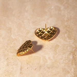 Elegant 18k gold plated heart studs featuring a quilted grid texture on marble background