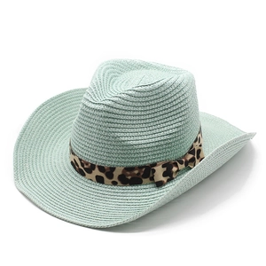 Detail of mint green woven straw cowboy hat with leopard print ribbon and bow decoration