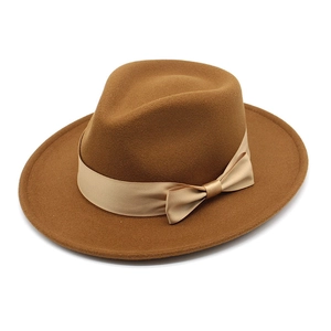 Detail of wool fedora hat with elegant champagne gold satin ribbon and a bow decoration