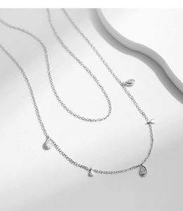 Vue macro de pendentifs en argent en forme de goutte avec pierres sur chaîne s925