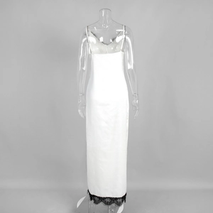 Détail de robe en satin blanc avec bordure en dentelle noire à l'ourlet et coupe au dos
