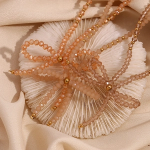 Handmade beaded necklace with champagne faceted crystals and golden bow accent on silk