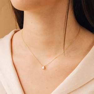 Minimalist gold necklace featuring a pear-shaped zircon pendant on a delicate chain
