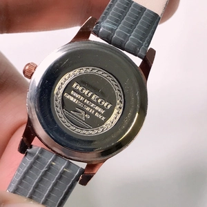 Macro shot of DOUKOU watch stainless steel back and grey textured leather strap