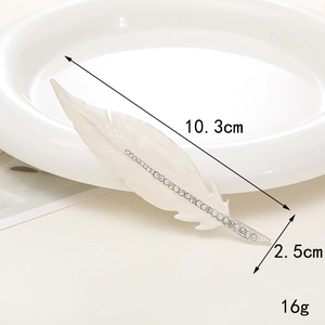 Detailed view of white feather charm with silver rhinestones and 10.3cm size label