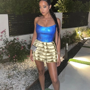 Detail of high-waist golden metallic shorts and blue tube top set for women in outdoor view