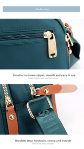 Close-up of golden metal zipper and durable D-ring on dark green nylon shoulder bag