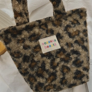 Close-up of leopard print plush bag with high-density faux fur texture and woven label