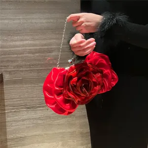 Detail of red satin rose petal evening bag with silver chain strap and 3D floral texture