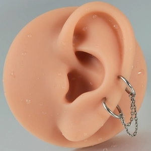 Macro view of double stainless steel ear hoops with thin dangling link chain detail