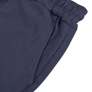 Detail of navy linen pants featuring elastic drawstring waist and side pockets